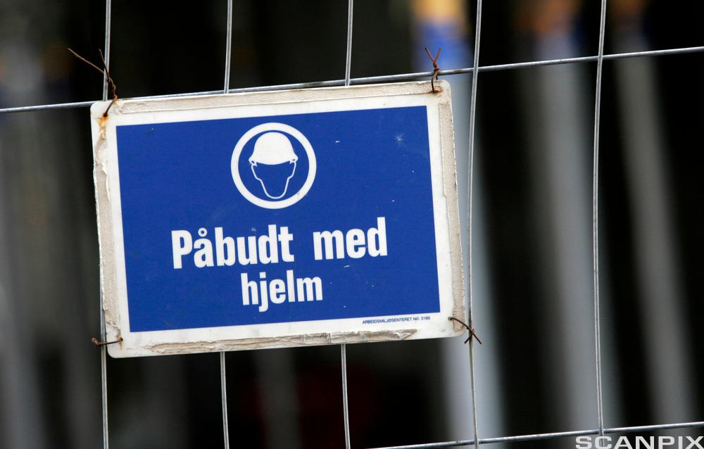 Skilt: påbudt med hjelm. foto.