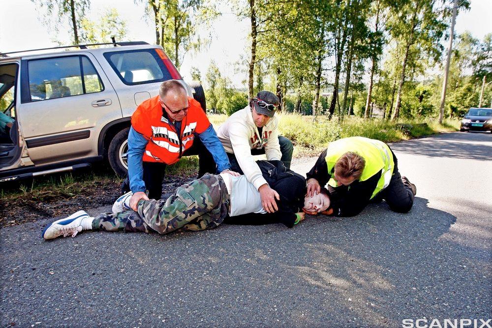 En skadet blir lagt i stabilt sideleie. Foto.