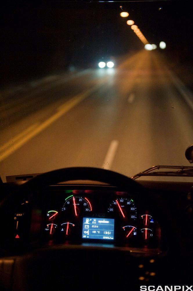 Styret og dashbordet til en bil i mørket. Foto.