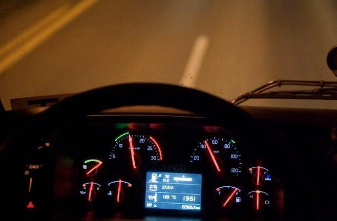 Styret og dashbordet til ein bil i mørkret. Foto.