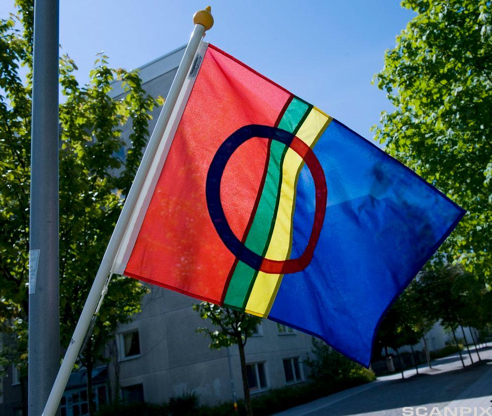 Foto av samisk flagg som henger fra en stolpe.