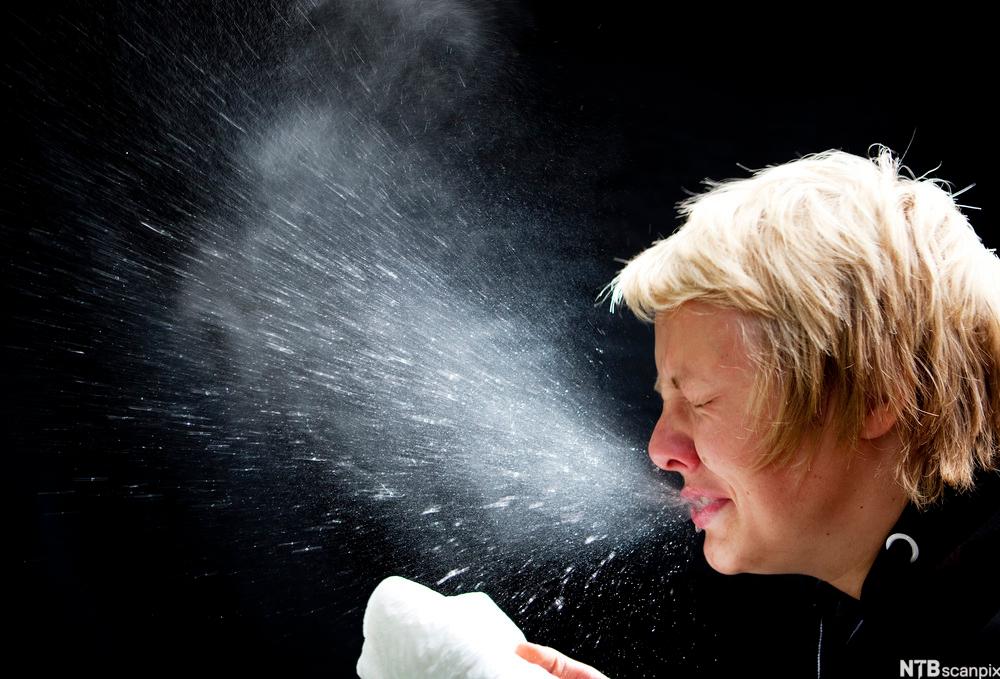 Bilde av en tenåring som nyser slik at dråpeskyen vises tydelig.