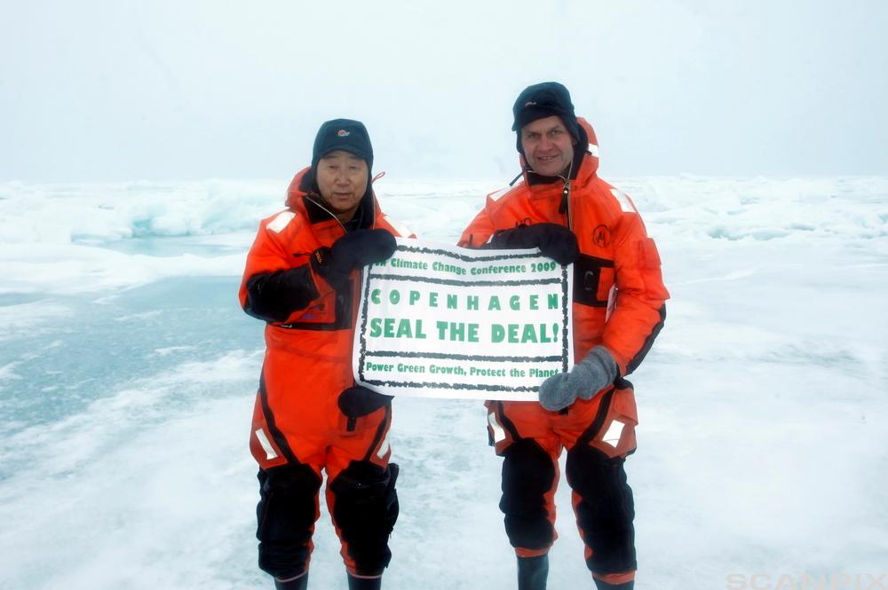 Ban Ki-moon og Erik Solheim står i isen og holder et banner med teksten "Seal the Deal" og Climate Change Congress 2009. Foto.