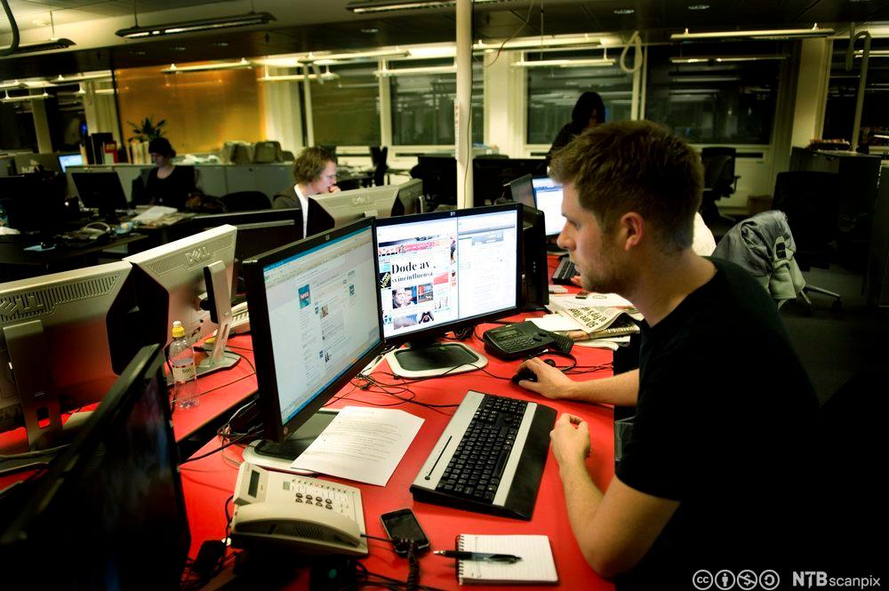 Journalist Mads A. Andersen foran PC-skjerm i VGs redaksjonslokale. Fotografi.