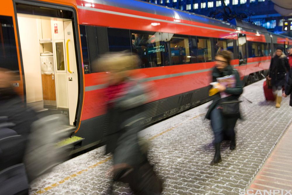 Personer som haster mot toget. Foto.