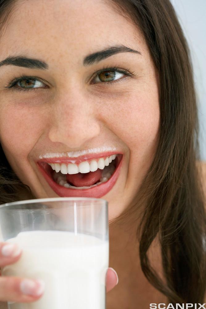 Kvinne drikker melk. Foto.