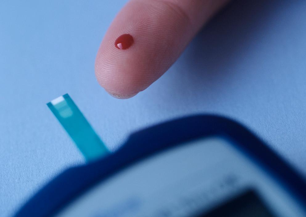 Måling av blodsukker, nærbilde av finger med en bloddråpe på. Foto.