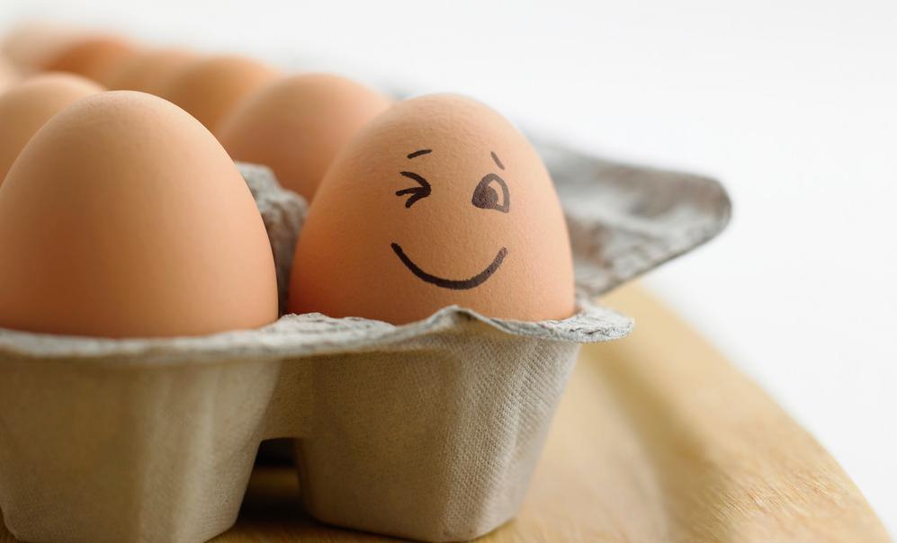Eggekartong med brune egg. Ett av eggene har et påtegnet smilefjes. Foto.