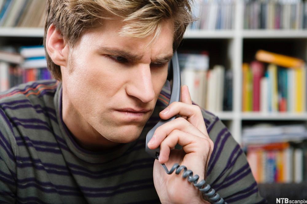 Bilde av sint mann i telefon