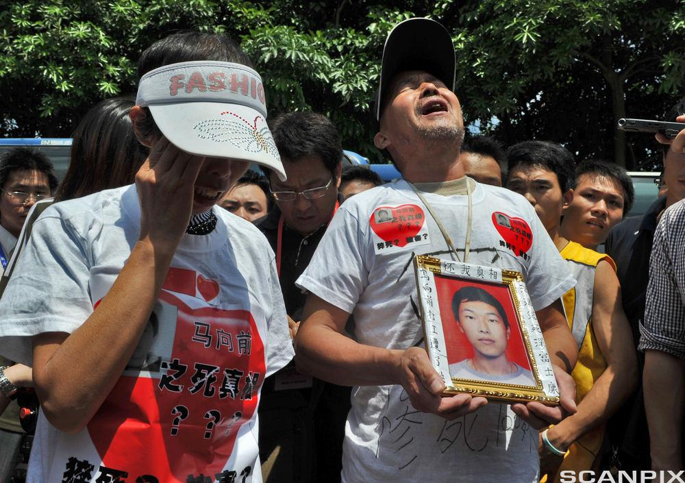 Foxconn suicides: The parents of a Foxconn employee who died last January 23, 2010 display a portrait of theur son as journalist