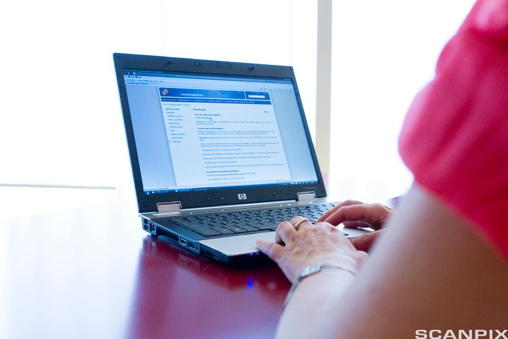 Woman writing on a laptop. Photo.