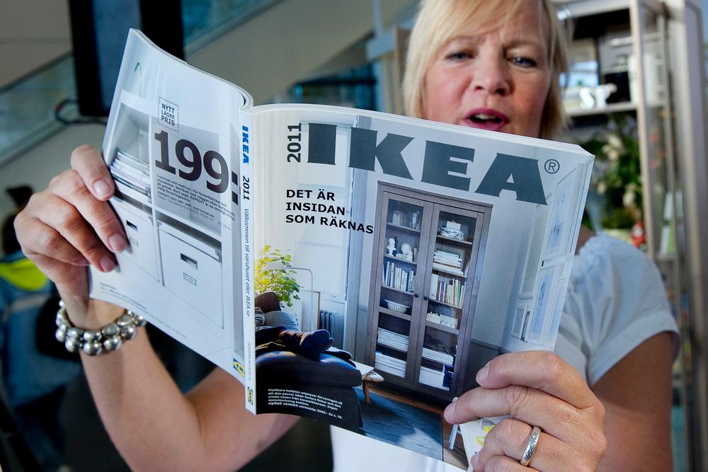 Kvinne som ser i ein IKEA-katalog. Foto.