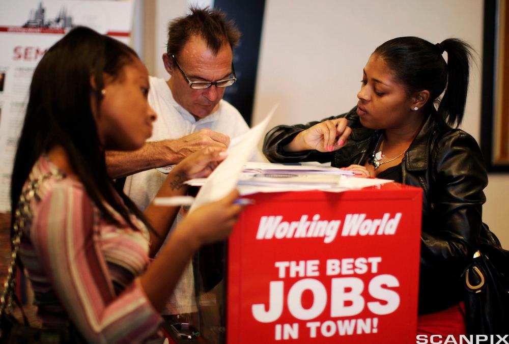People fill out job application forms at a job fair in Los Angeles, California
