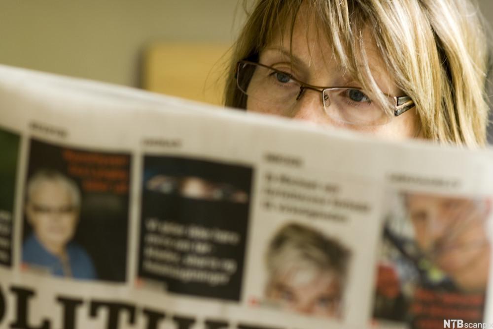 Kvinne leser en avis. Foto.