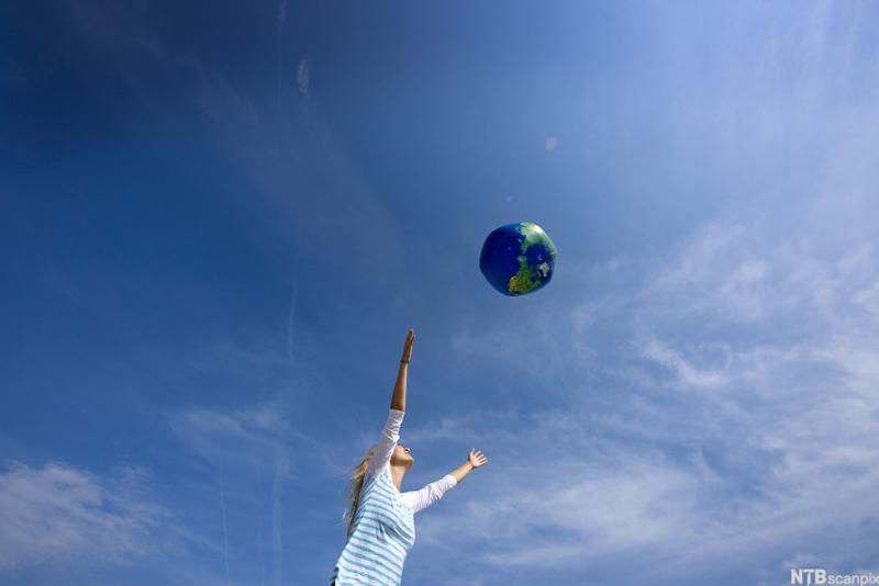 Bilde av en kvinne som kaster på en oppblåsbar ball som ser ut som jordkloden