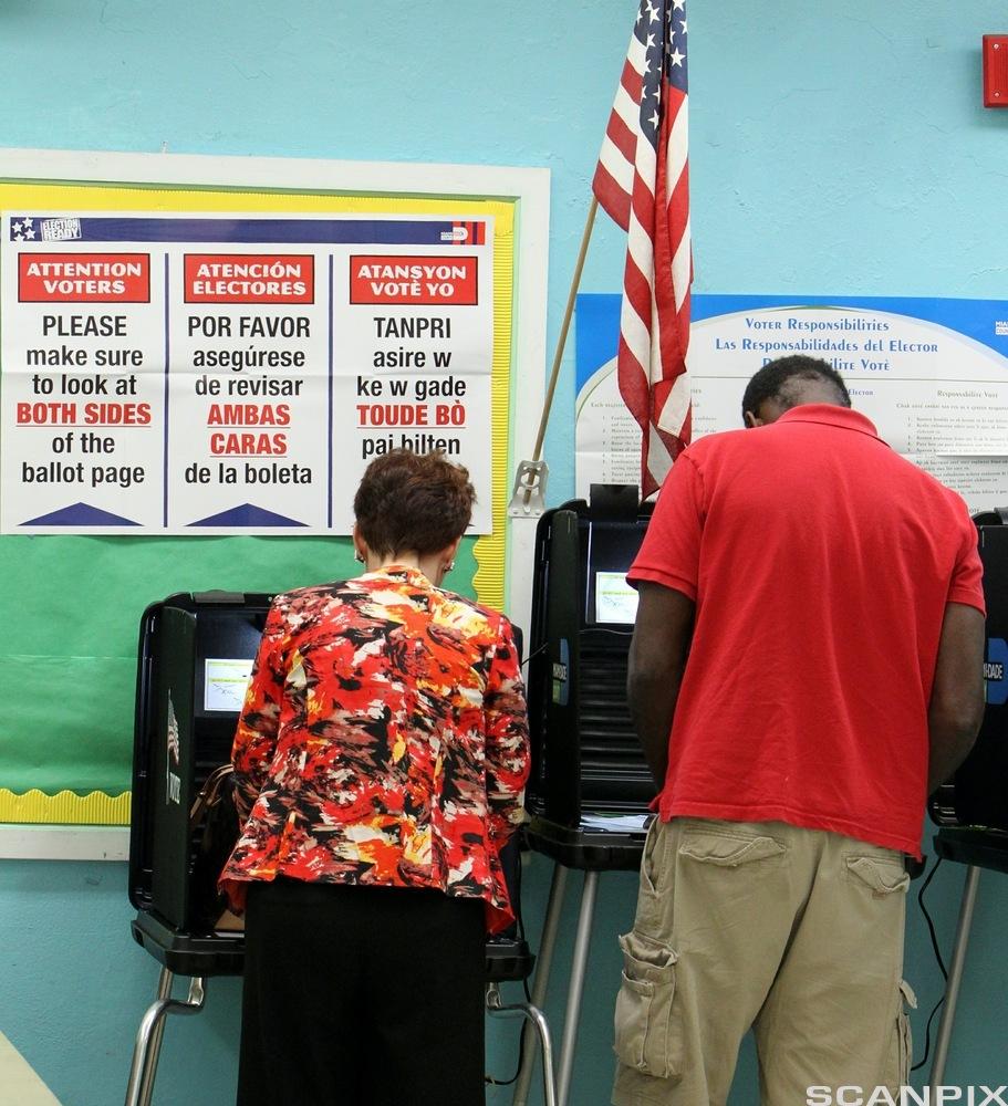 Florida Voters Head to Polls for Midterm Elections. Voters mark their ballots in polling place featuring instructions in English