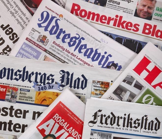 Ein bunke med aviser frå ulike stader i Noreg. Foto.