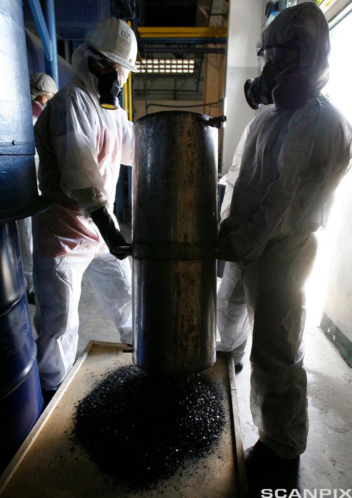 Arbeidere som heller ut metallegering med karbon ”char” produsert fra elektronisk avfall. Foto.