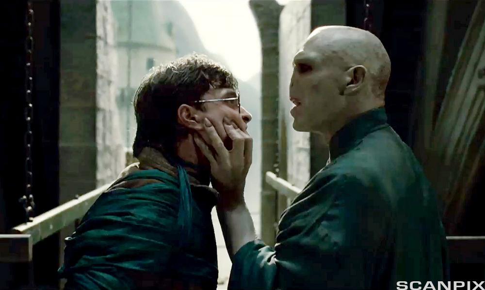 Voldemort griper rundt Harry Potters ansikt og ser truende på ham i en scene fra spillefilmen Harry Potter. Foto.