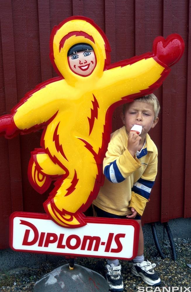 Bilde av en gutt som spiser is ved reklameskilt for Diplom-Is.