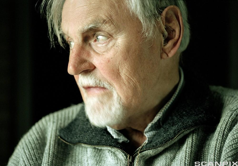 Nærbilde av gammel mann med skjegg og grått og hvitt hår. Foto.