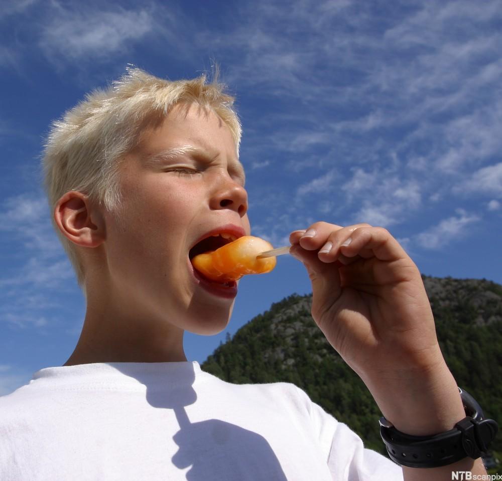 Gutt, 8 år, nyter en is med lukkete øyne