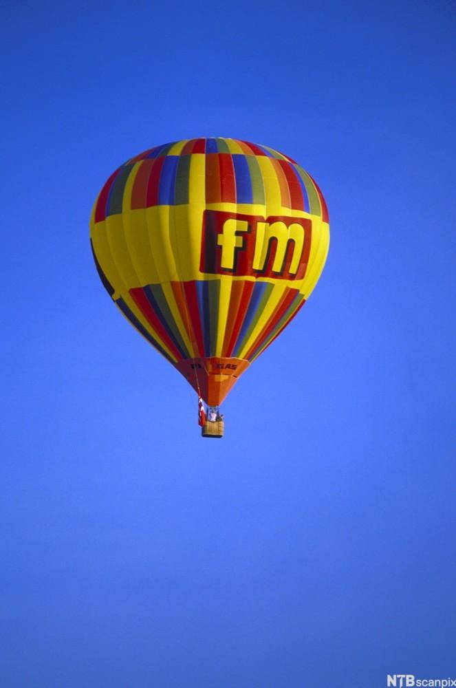 Varmluftsballong med reklame, med blå himmel i bakgrunnen. Foto.