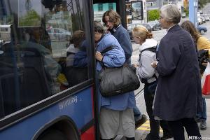 Folk går på bussen. Foto.
