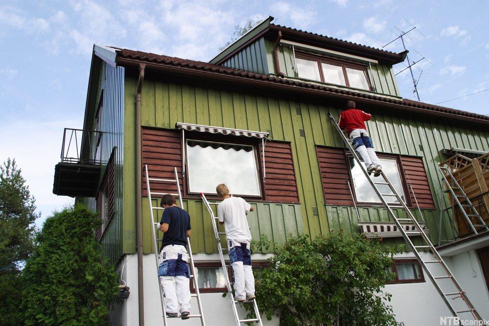 Bilde av arbeidere som maler og vedlikeholder en enebolig. Foto