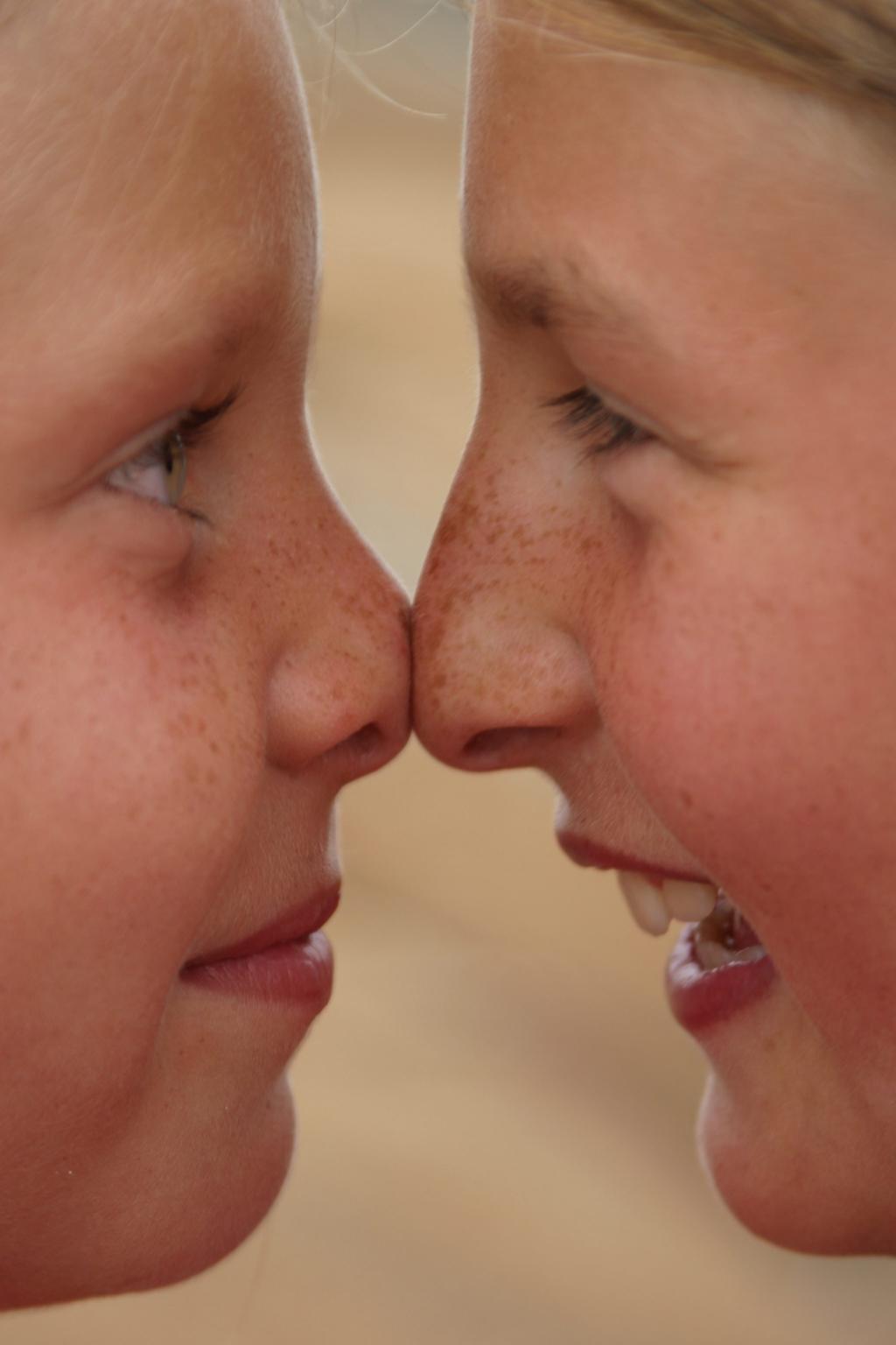To barn som pressar nasane mot kvarandre. Foto.