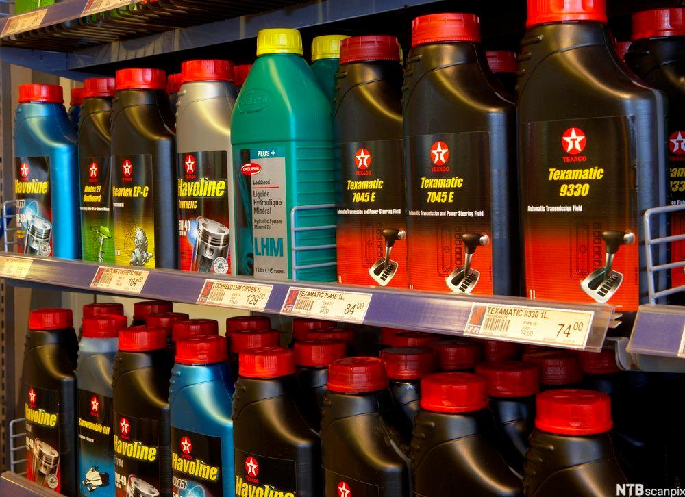 Oljeflasker på rekke og rad i butikkhyller. Foto.