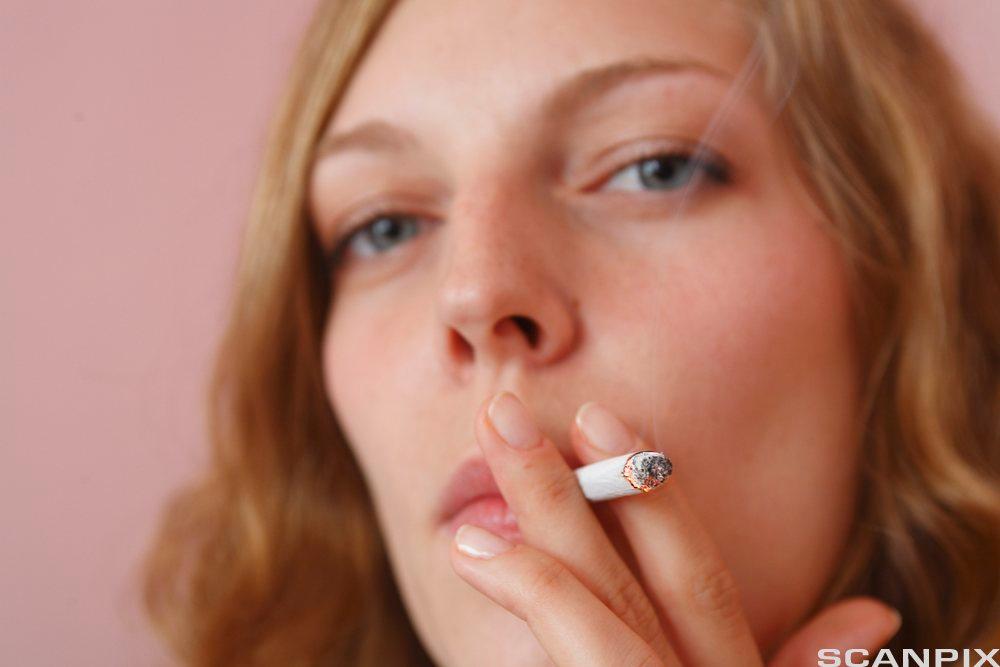 Ung kvinne med sigarett. Foto.