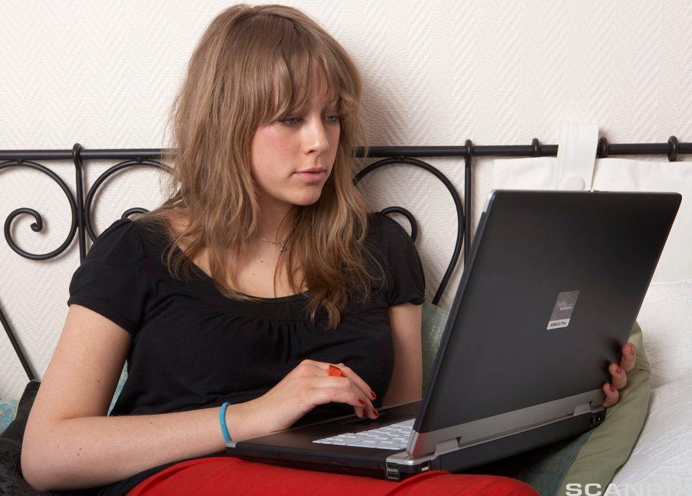 Kvinne holder en laptop-PC. Foto. 
