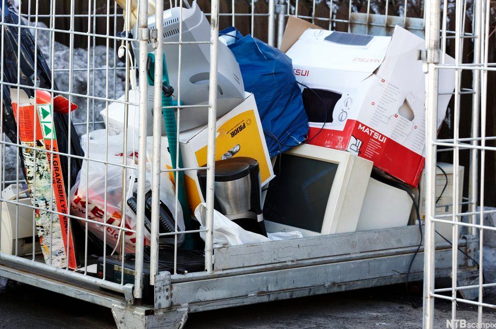 Foto av palleramme med elektrisk avfall, mellom anna ein mikrobølgeomn, ein dataskjerm og ein kaffitraktar.