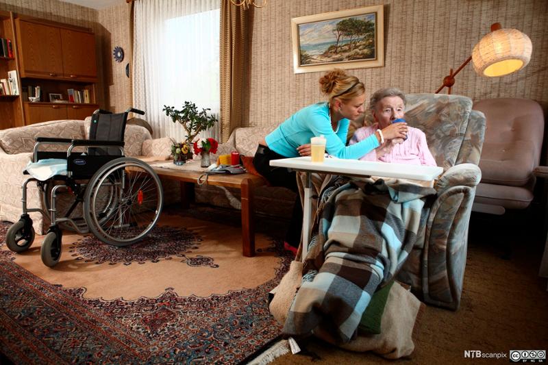  En kvinnelig hjemmehjelp og eldre kvinne kommuniserer. Foto. 