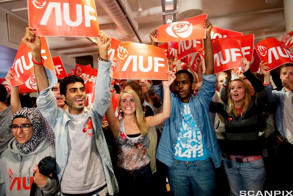 Valgvake med AUF. Ungdommer holder opp plakater med "AUF" på. Foto. 