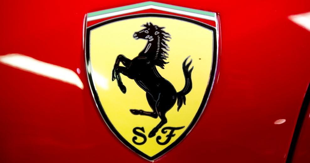 Ferrari-logoen i fargene rødt, gult, svart, grønt og hvitt. En svart hest som står på to bein er midt i bildet. Foto.