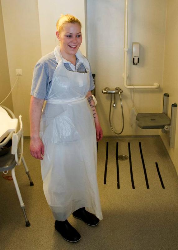 Pleier med plastforkle og gummistøvler. Foto.