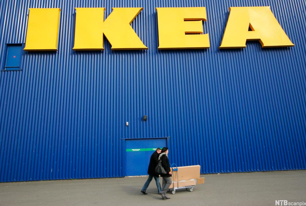 Bilde av et par med handlevogn utenfor et IKEA-varehus. Foto.