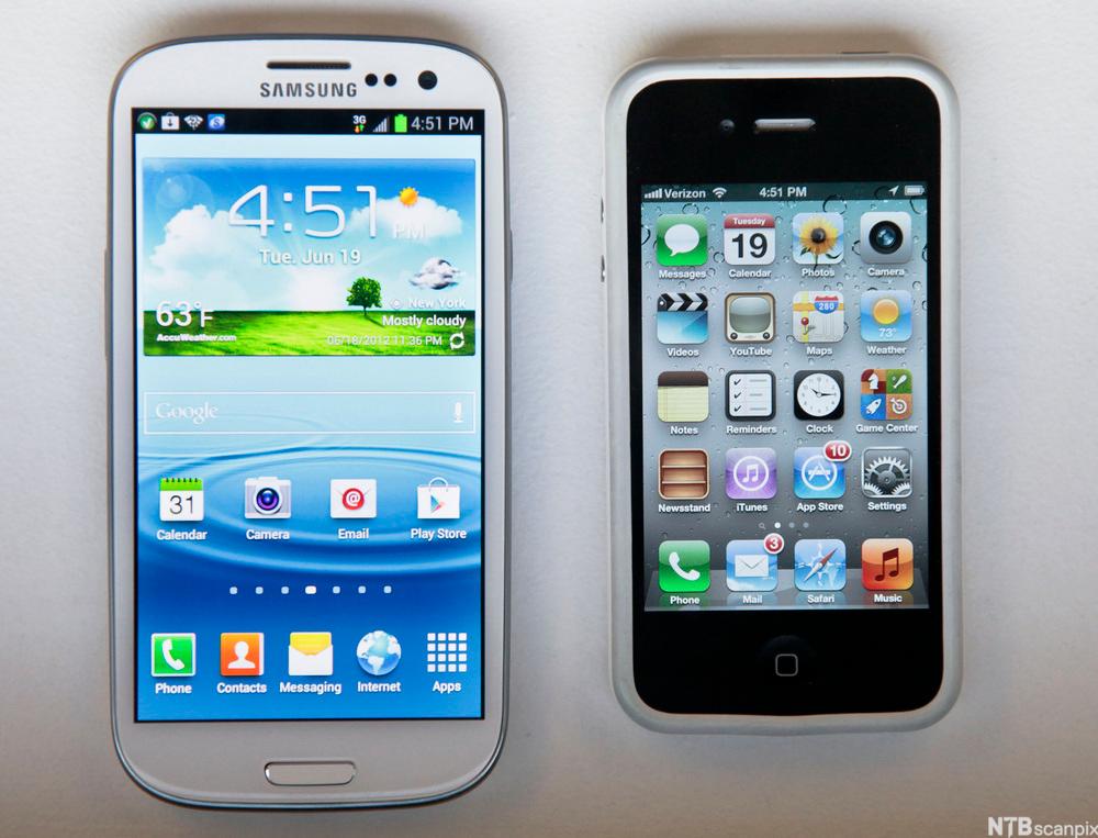 En Samsung-telefon og en Apple iPhone ligger ved siden av hverandre. Foto.