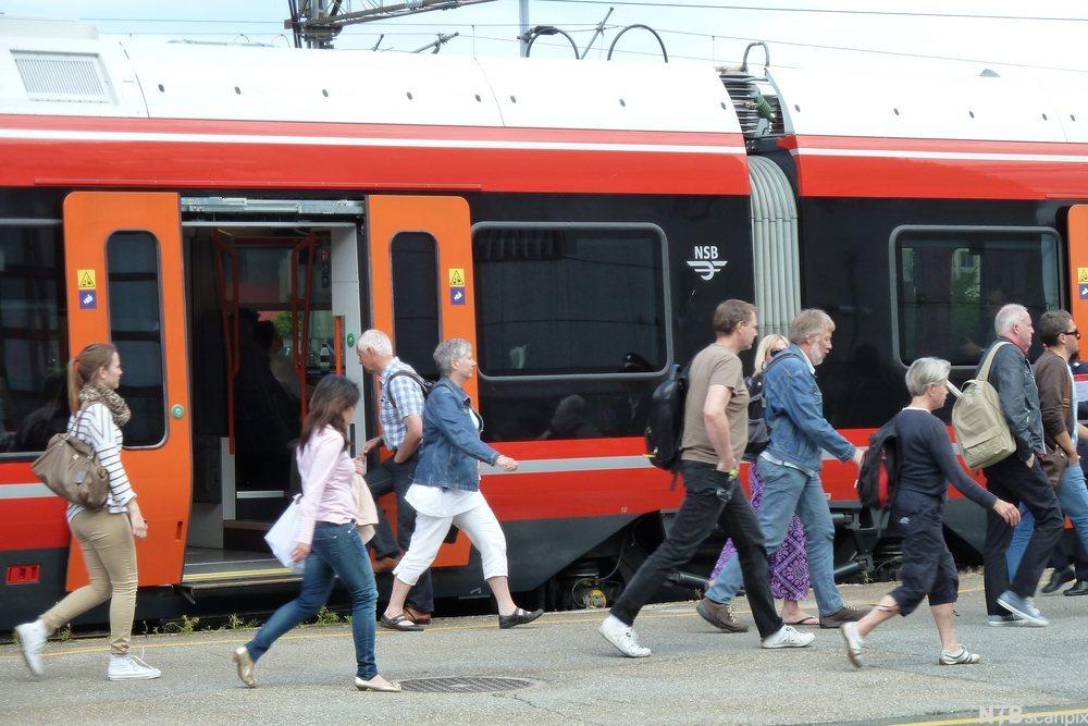 Passasjerer foran tog på perrong. foto.