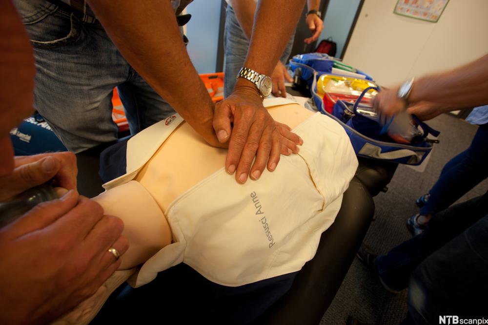 Tre personar øver på hjarte- og lungeredning på ei førstehjelpsdokke. Foto.