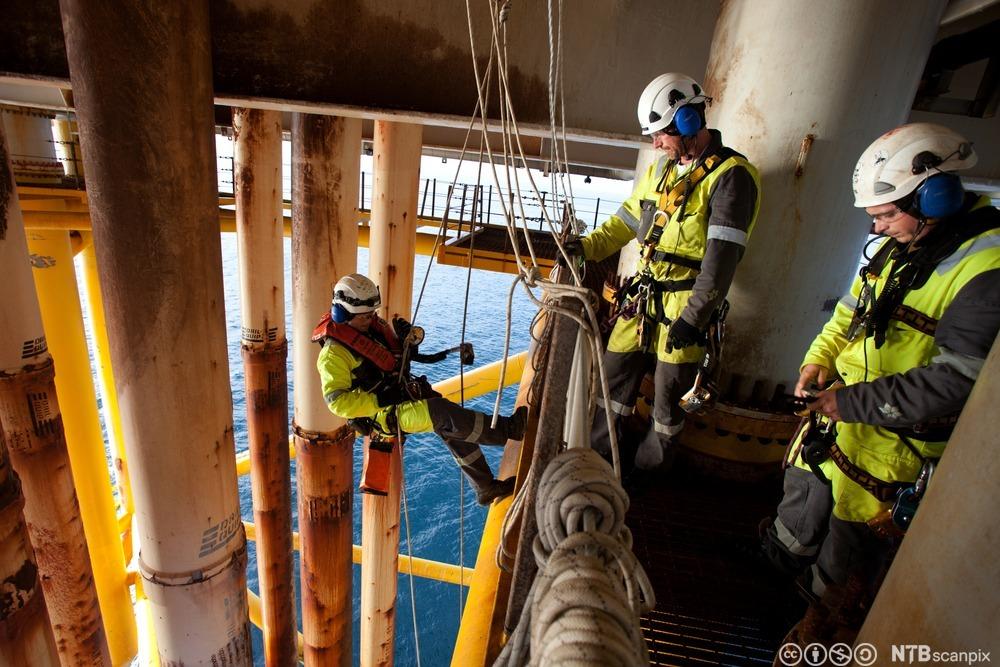 Tre klatrarar i arbeid på ei plattform i Nordsjøen. Foto.