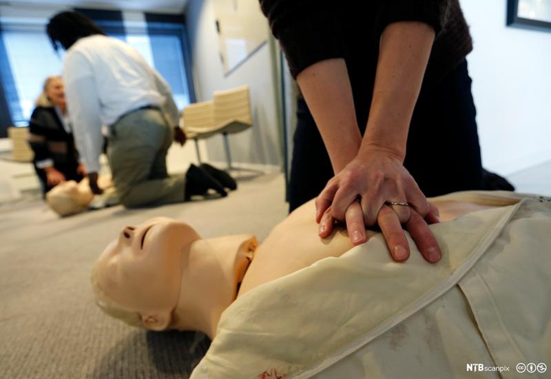 En person øver på hjertekompressjon på en førstehjelpsdukke. Foto.