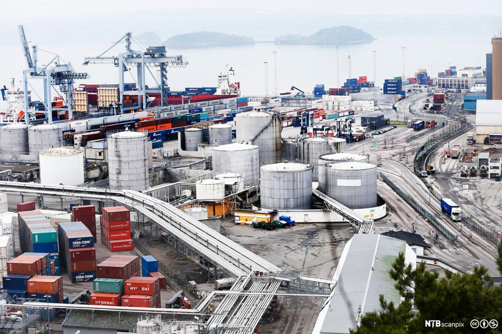 Kontainerhavn med tanker, kontainere, rørgater, veier, heisekraner, skip og lastebiler.Foto.