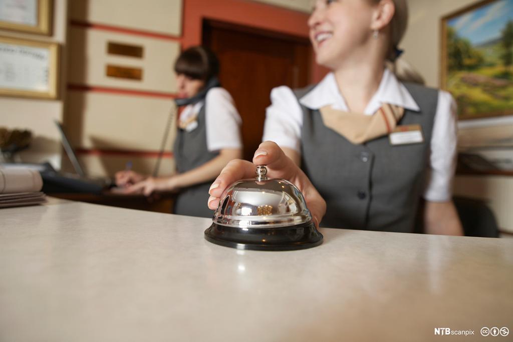 Smilende kvinnelig resepsjonist på hotell.