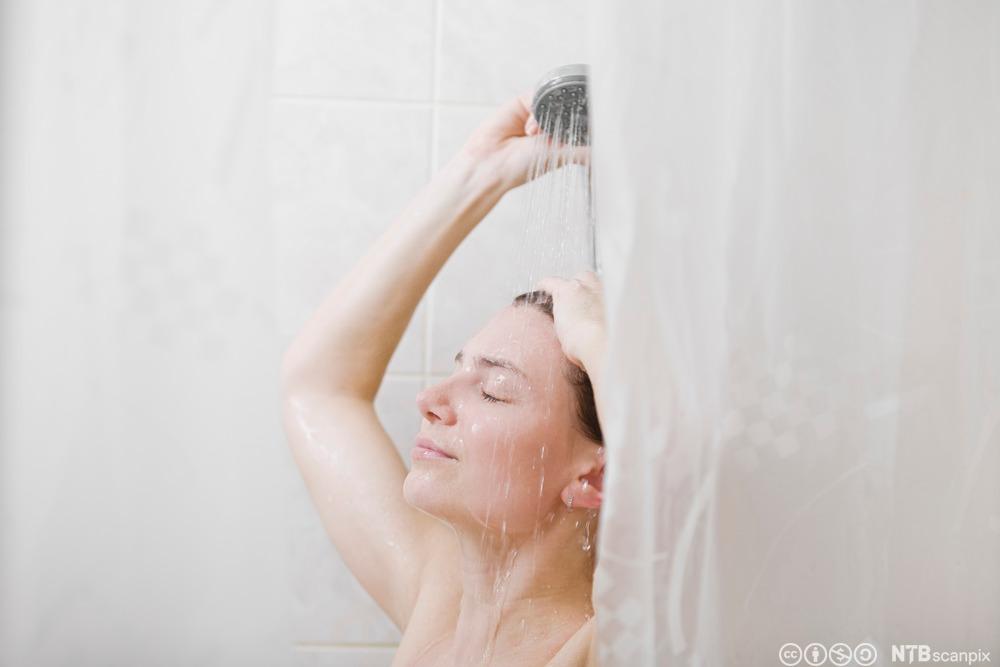 Kvinne som dusjer. Foto.