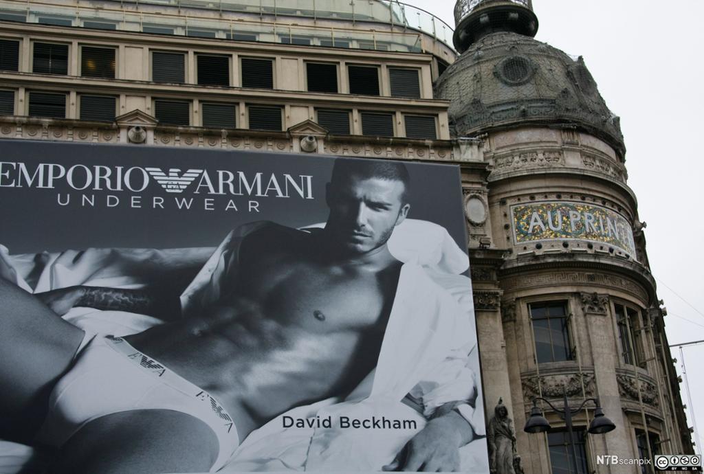 Fotballspiller David Beckham poserer i boxsershort på stor reklameplakat på husfasade. Foto.