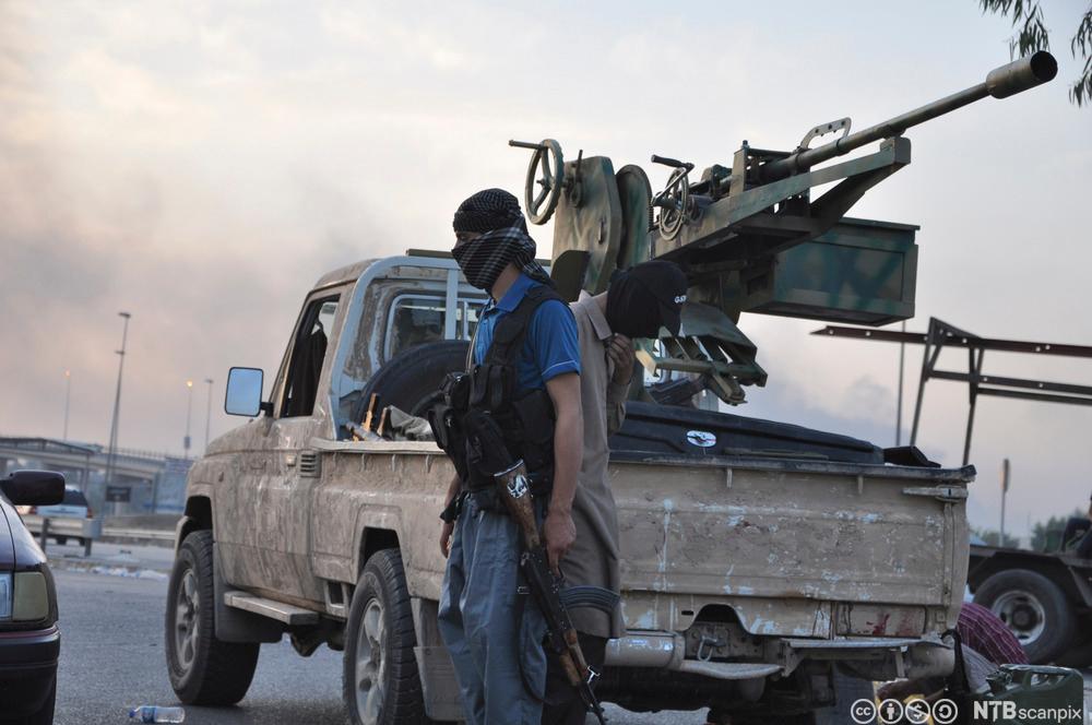 En bil og to tildekkede IS-soldater med våpen i Mosul. Foto. 