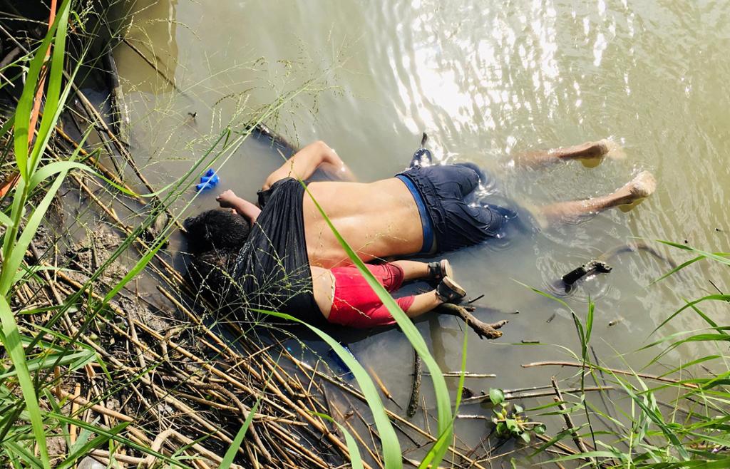 Ung mann med et lite barn ligger druknet i vannkanten. Foto.